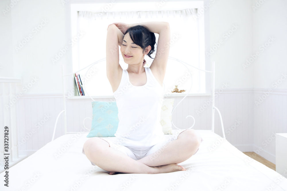 ベッドで体操をする女性