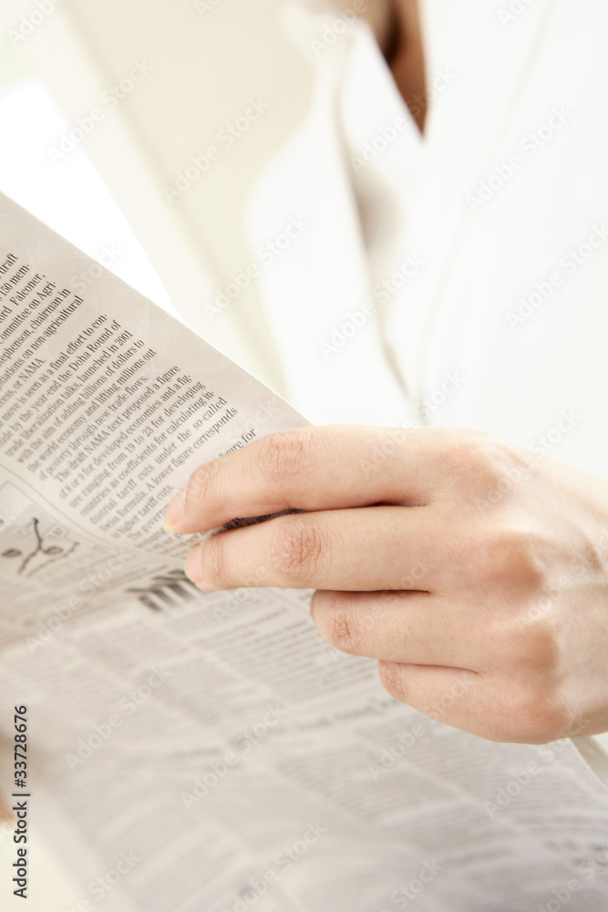 Naklejka premium 新聞を読むビジネスレディの手