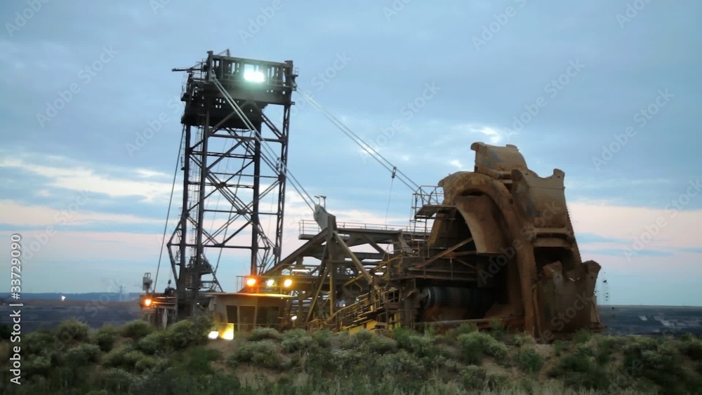 Giant bucket wheel excavator at work in twilight Giant bucket wheel excavator at work in twilight