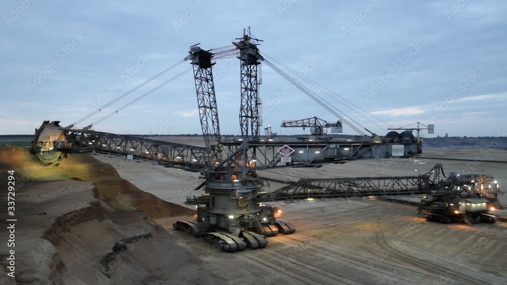 Giant bucket wheel excavator at work in twilight Giant bucket wheel excavator at work in twilight