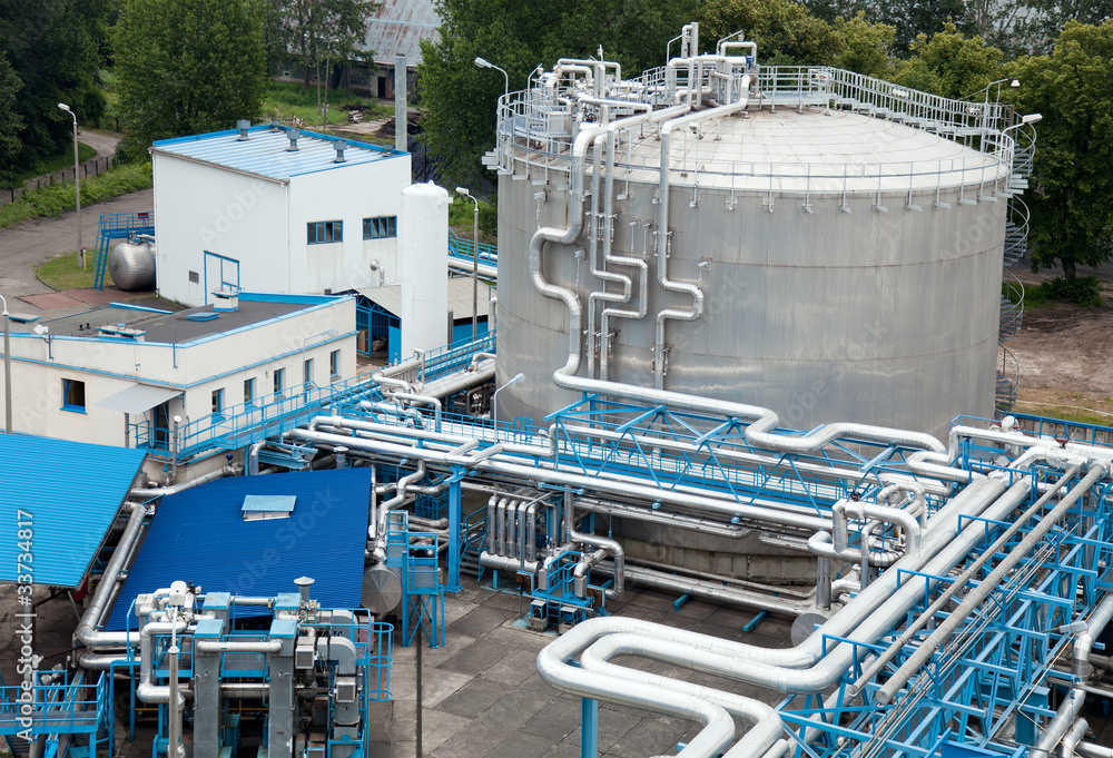 Silver industrial oil container with stairs in a refinery Silver industrial oil container with stairs in a refinery