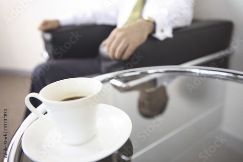 コーヒーとソファに座る社長