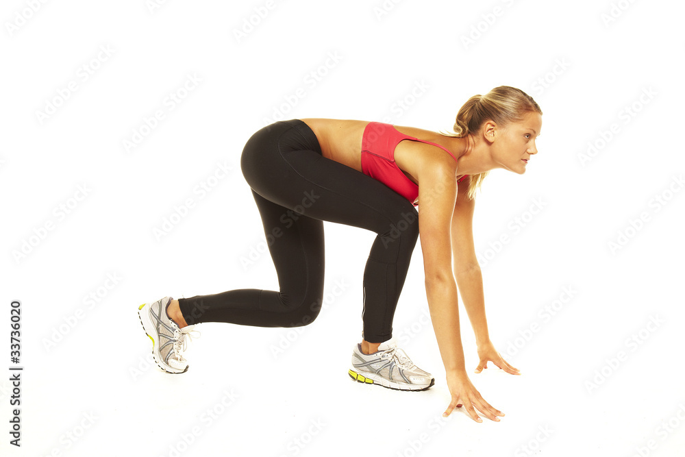 Athletic woman on track starting to run