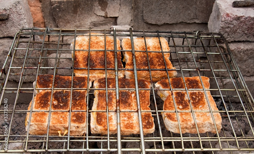 Tablou pe pânză Cheese sandwiches toasted over coals in grid
