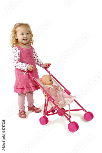 Little girl pushing a pram