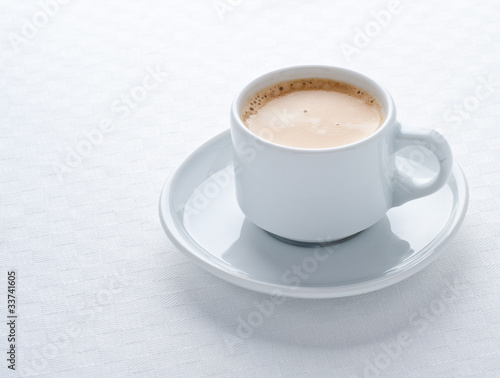 Coffee cup on white tablecloth