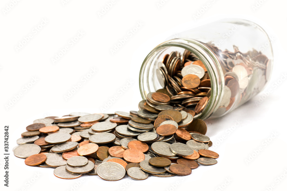 Jar Of US Coins Spilled On A White Background Jar Of US Coins Spilled On A White Background