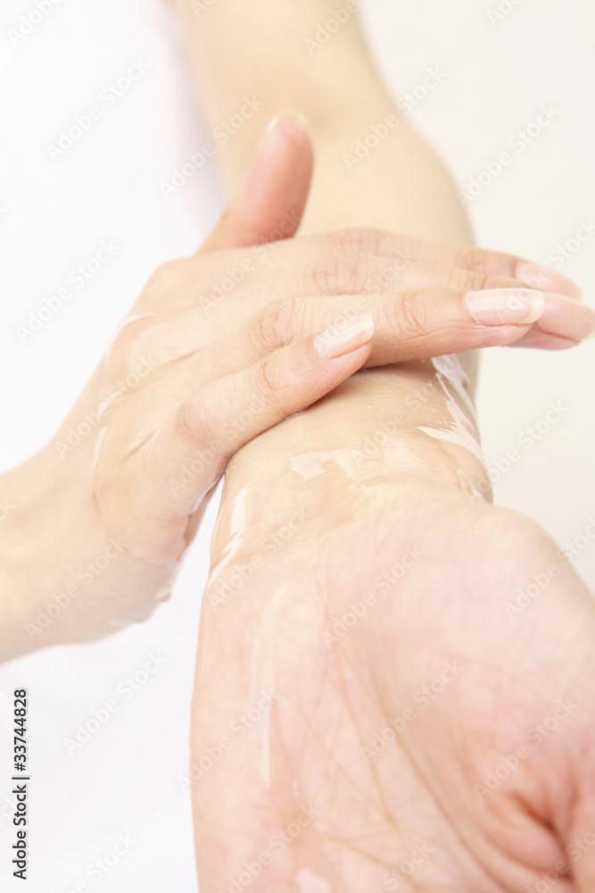 Naklejka premium 化粧水を使う女性の手