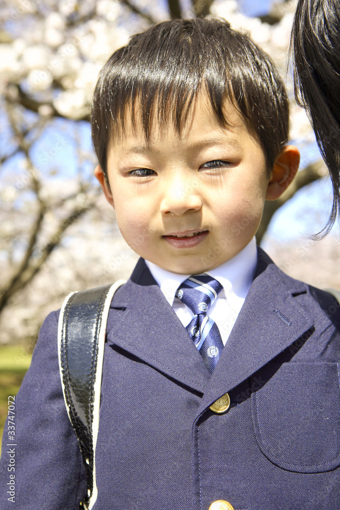 桜の前に立つ小学生男子