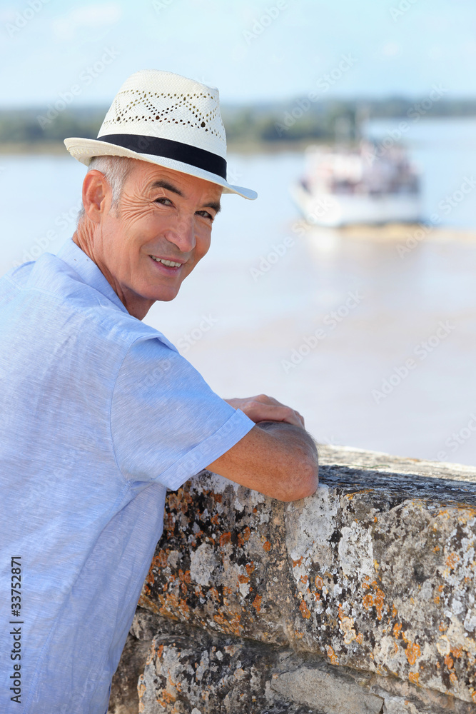 Smiling senior man watching the ferry from Blaye citadel, France