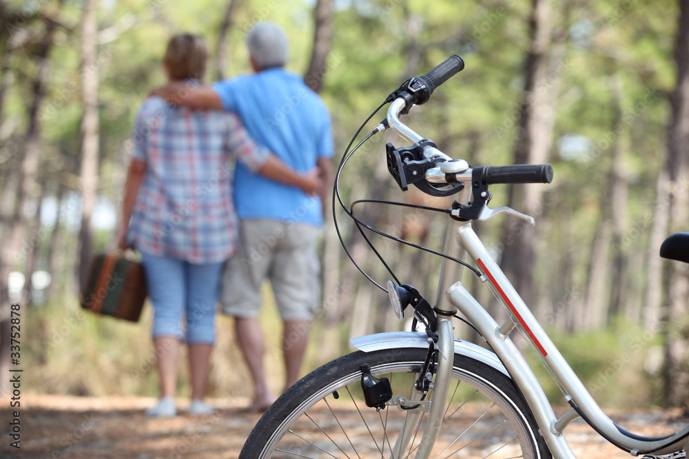 Fototapeta premium Couple taking a picnic to the woods by bike