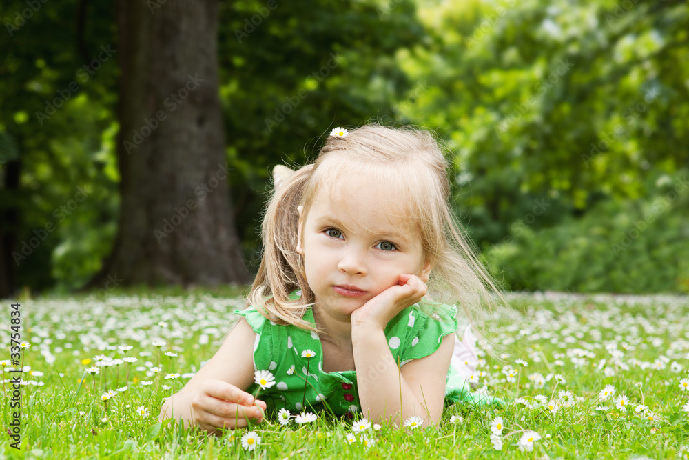 Beautiful little girl relaxing on a meadow Beautiful little girl relaxing on a meadow