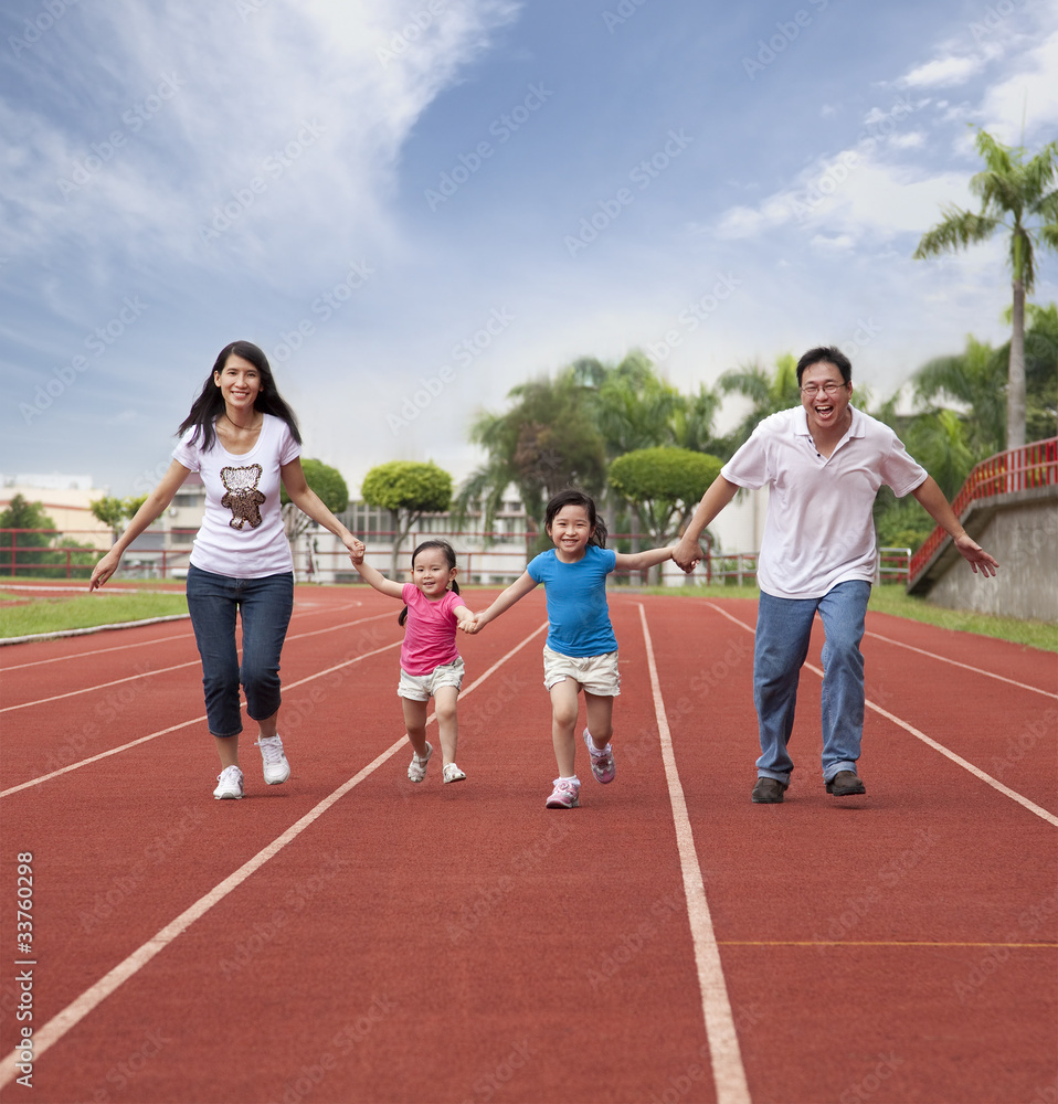 happy asian family running together on the Stadium track