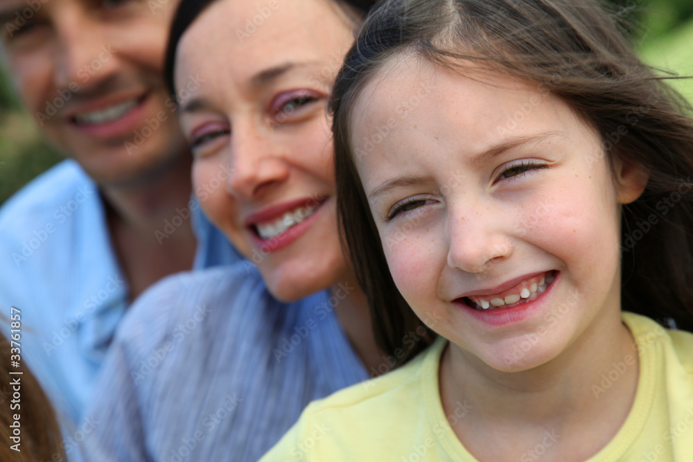 Portrait of smiling little girl with parents in background