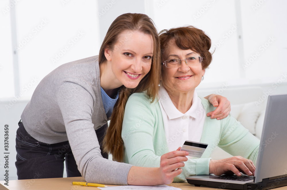senior woman with her daughter online purchasing senior woman with her daughter online purchasing