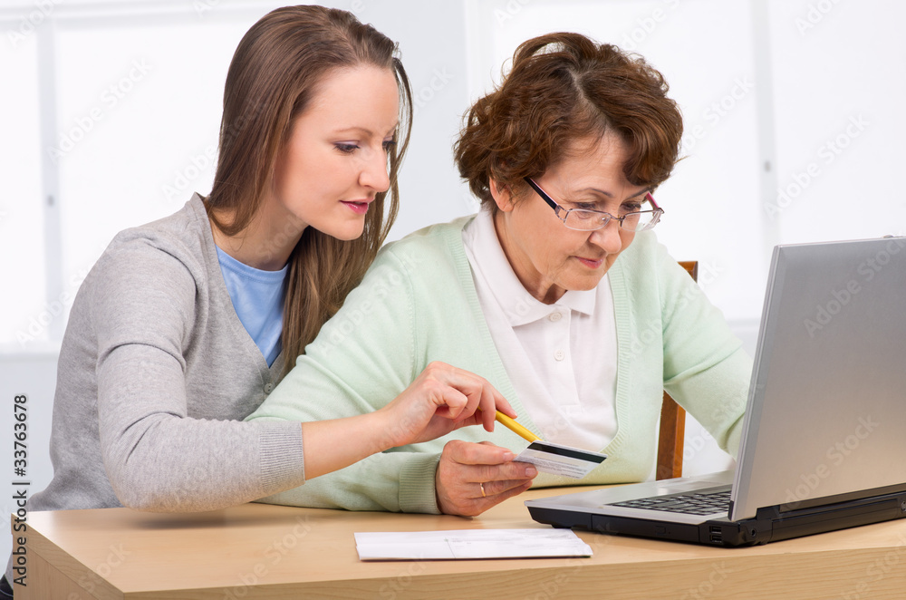 senior woman with her daughter online purchasing senior woman with her daughter online purchasing