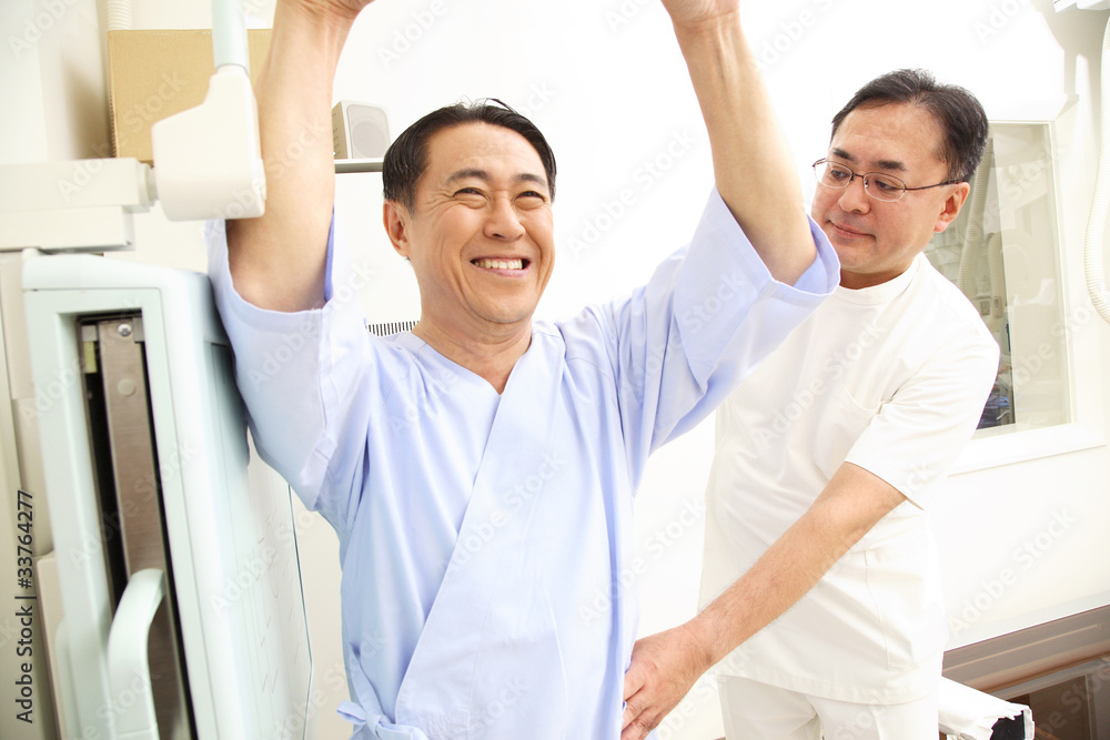 Obraz premium レントゲンをとる患者をサポートする技師