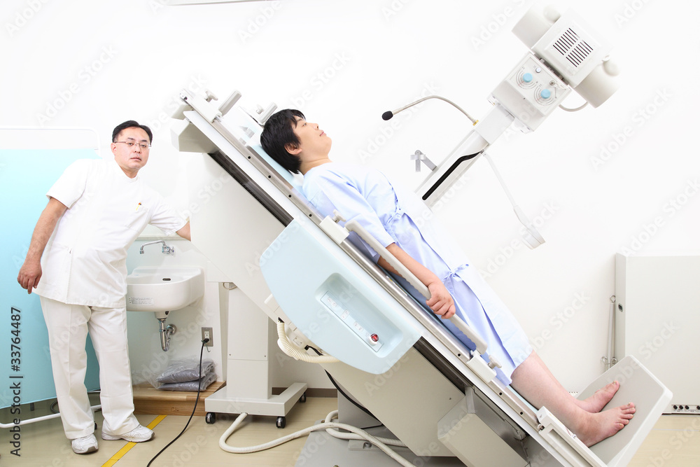 レントゲンをとる患者とサポートする技師 レントゲンをとる患者とサポートする技師