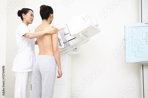 乳がんの検査を受ける患者とサポートする技師