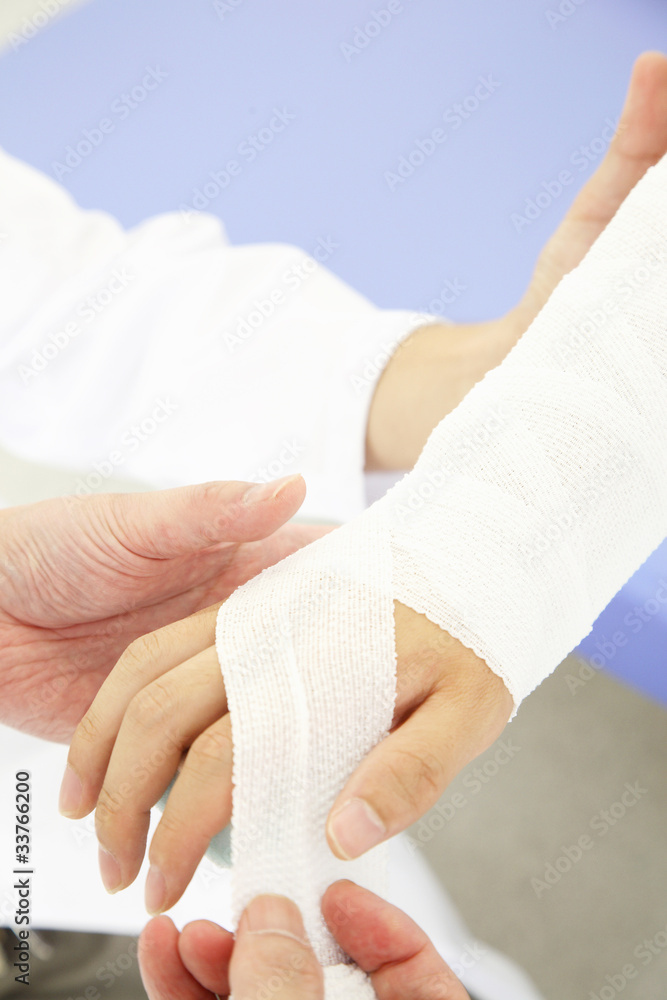 患者の腕を包帯で巻く医者の手元 Stock 写真 Adobe Stock