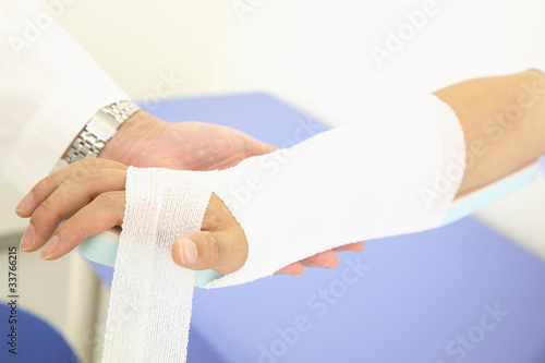 腕の骨折を包帯とシーネで固定する医者の手元 Stock Photo Adobe Stock