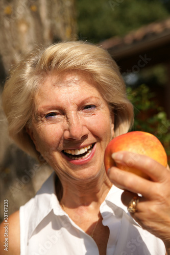femme sénior qui croque une pomme