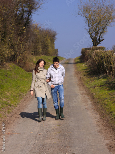 Couple of young people walking in the campaign in spring