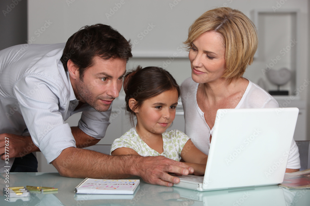Parents and child looking at computer screen Parents and child looking at computer screen