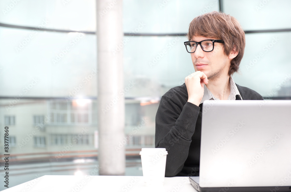 Friendly executive sitting in front of laptop Friendly executive sitting in front of laptop