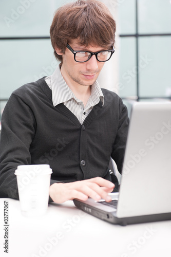 Friendly executive sitting in front of laptop