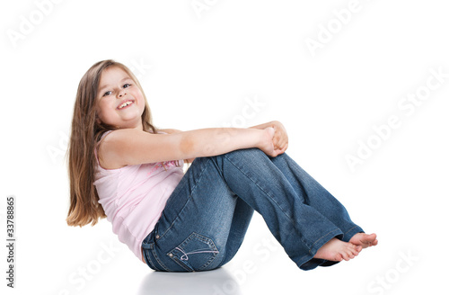 Cute happy little girl sitting on white background