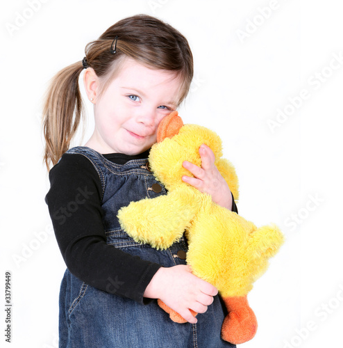Little girl hugging her stuffed toy on white