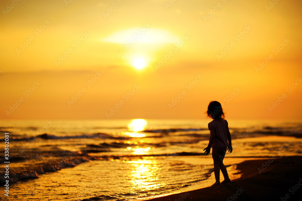 A child as silhouette by the sea