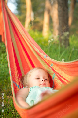 Adorable baby girl relaxing in hammock