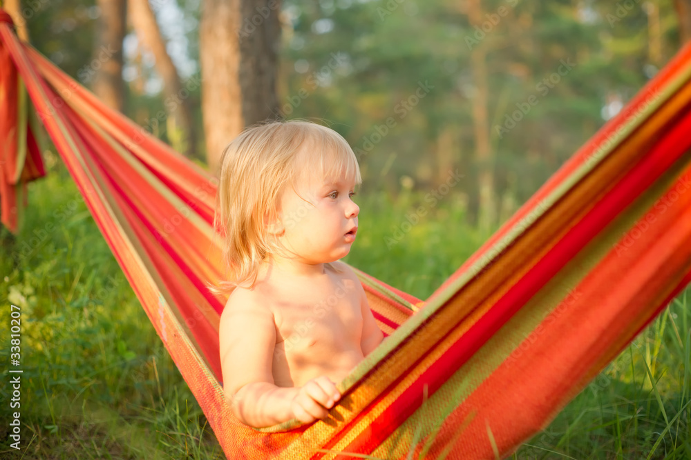 Adorable baby girl sit and look around relaxing in hammock Adorable baby girl sit and look around relaxing in hammock