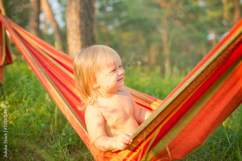 Adorable baby girl sit and look around  relaxing in hammock