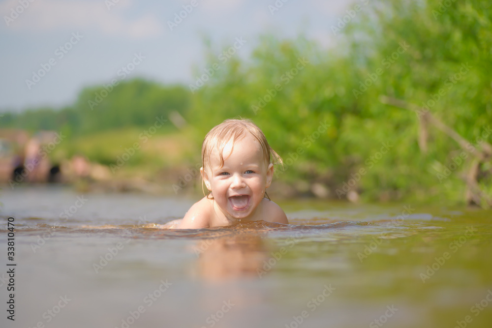 Adorable young baby swim in river