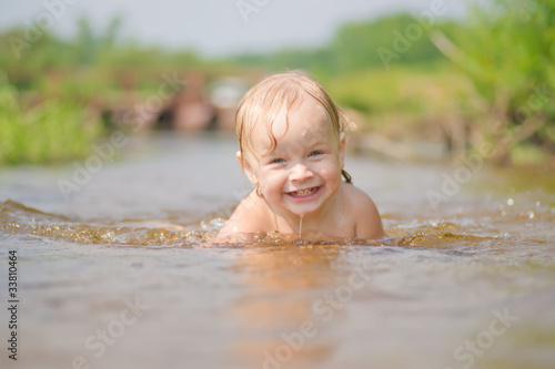 Adorable young baby swim in river