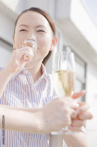 テラスでシャンパンを飲む2人の女性