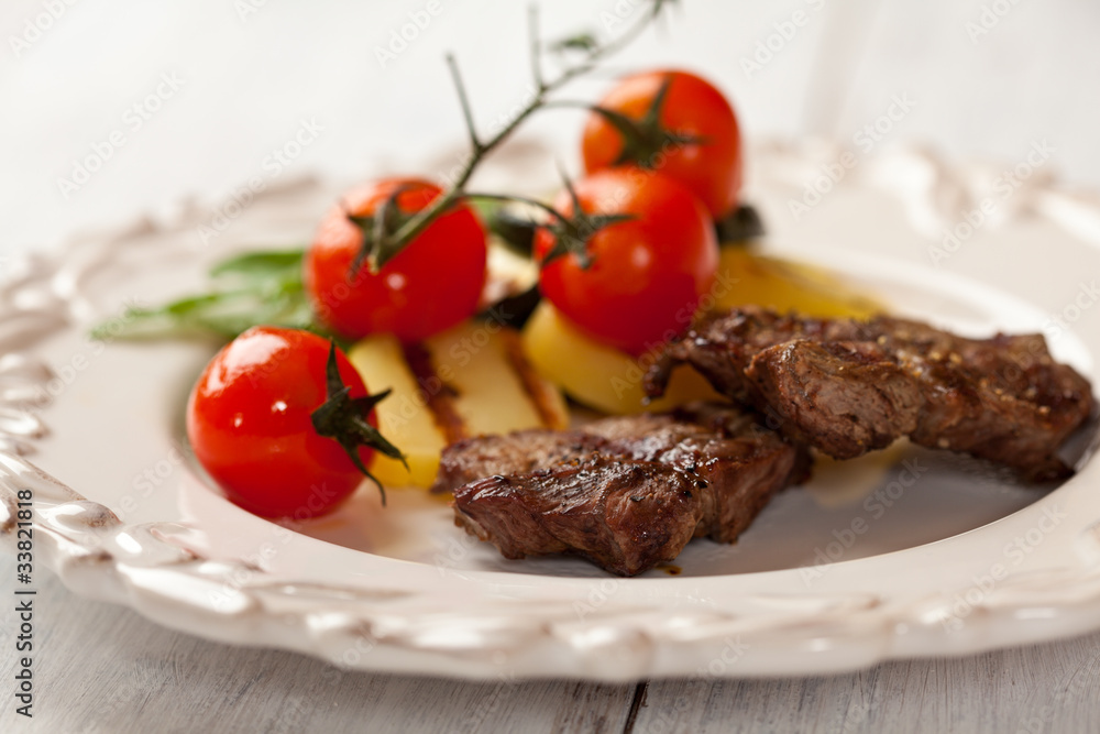 Rustic grilled beef dish with cherry tomatoes and potatoes Rustic grilled beef dish with cherry tomatoes and potatoes