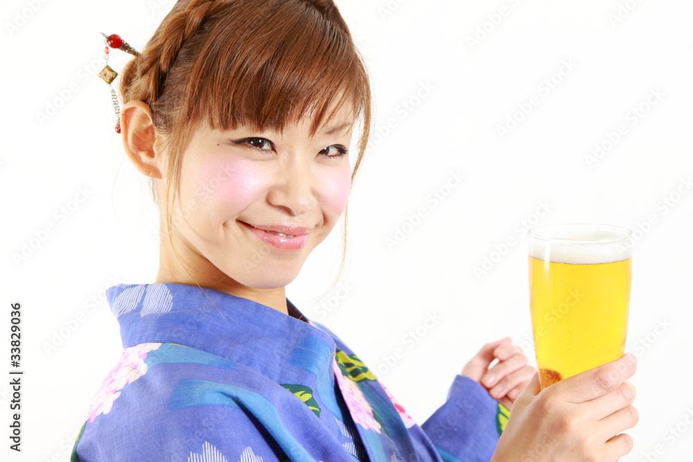 Young woman wearing Japanese kimono with a glass of beer Young woman wearing Japanese kimono with a glass of beer