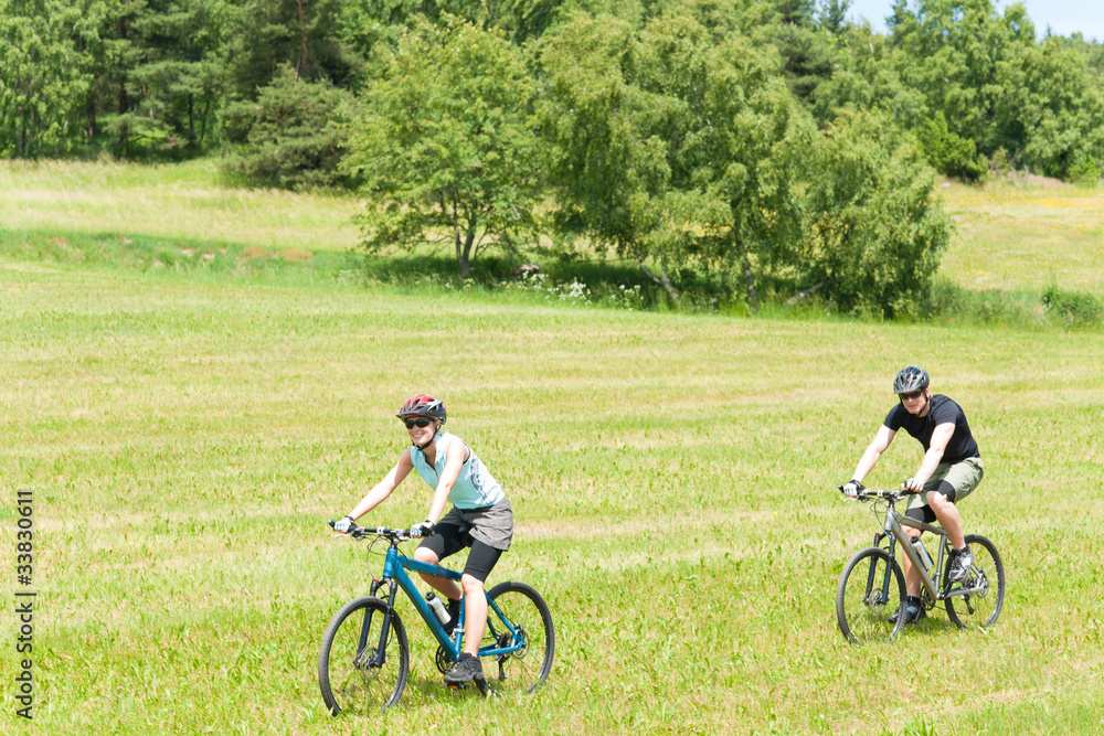 Sport happy couple riding bicycles in coutryside Sport happy couple riding bicycles in coutryside