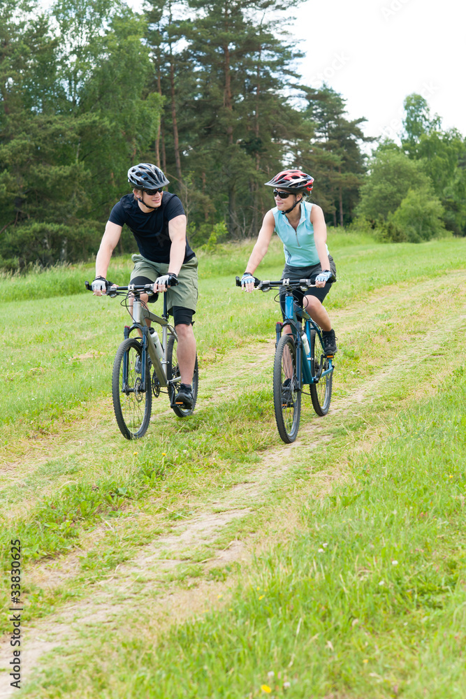 Sport happy couple riding bicycles in coutryside