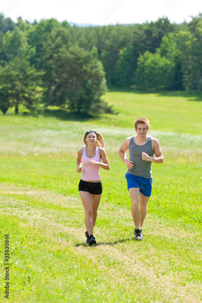 Sportive young couple jogging meadows sunny summer Sportive young couple jogging meadows sunny summer