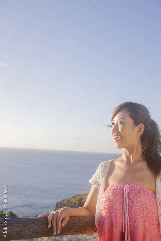 海辺で遠くを眺める女性