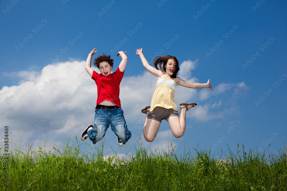 Girl and boy jumping, running against blue sky Girl and boy jumping, running against blue sky