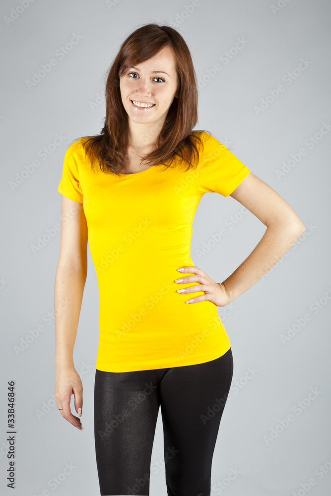 Young brunette in yellow top posing on white background Young brunette in yellow top posing on white background
