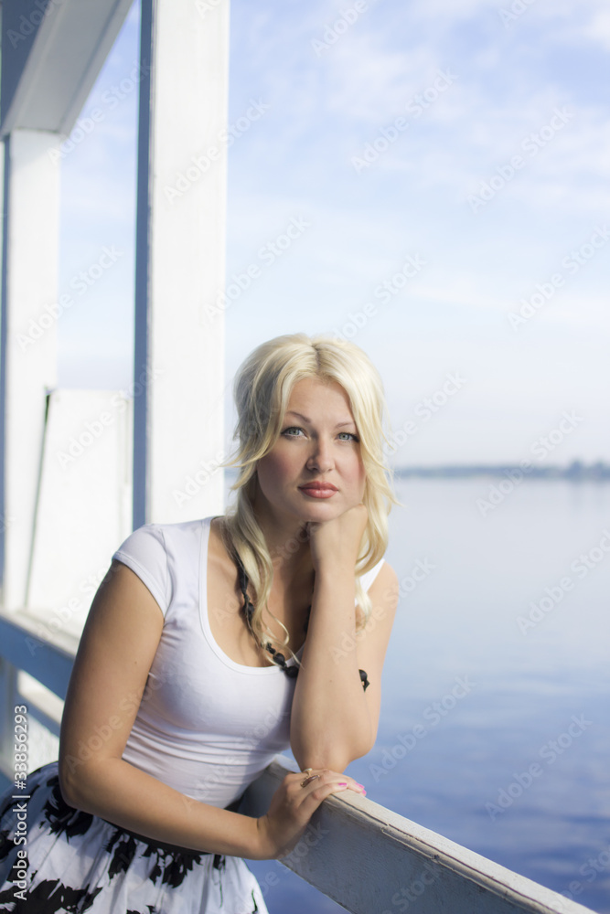 Portrait of young beautiful girl standing at the landing stage