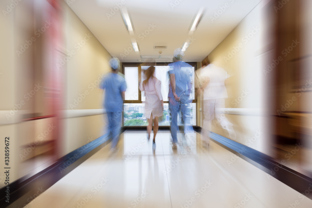 Surgeon and nurse running in passageway