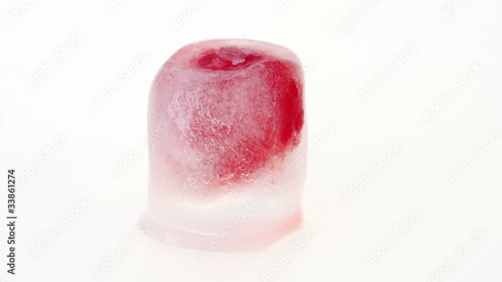 One raspberry berry inside of melting ice cube, time lapse One raspberry berry inside of melting ice cube, time lapse